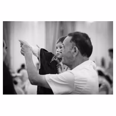 Photographie noir et blanc d'un enfant dans les bras d'un adulte