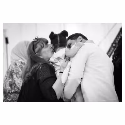 Photographie noir et blanc de deux personnes embrassant une enfant
