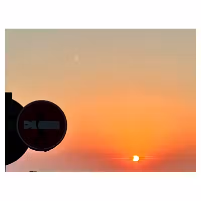 Coucher de soleil après l'éclipse du 12 aoüt 2026, avec un panneau de sens interdit au premier plan.
