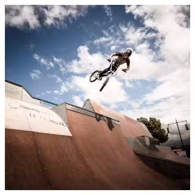 adolescent effectuant un saut à vélo BMX sur un tremplin de skatepark