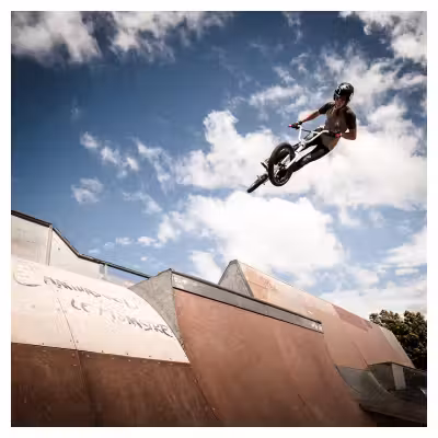 adolescent effectuant un saut à vélo BMX sur un tremplin de skatepark