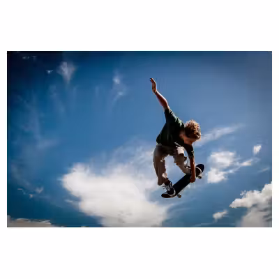 Photo d'un skater effectuant un saut sur fond de ciel