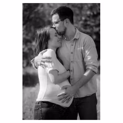 photographie noir et blanc d'un couple de jeunes parents s'enlaçant, dont la femme est enceinte #1