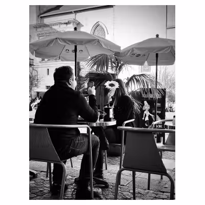 un couple à table en terrasse de restaurant, chacun sur son téléphone portable