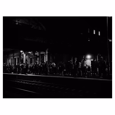 Quai de gare rempli de personnes dans la nuit