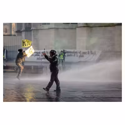 homme arrosé par les forces de l'ordre dans une manifestation