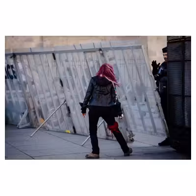 une manifestante semble danser devant un policier qui la salue de la main