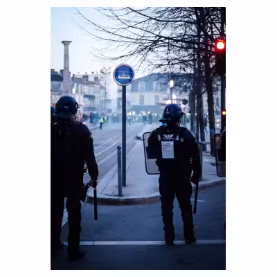 policiers de dos dans des fumées lors d'une manifestation
