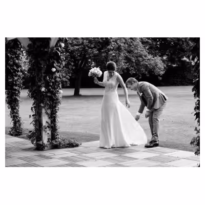 le père d'une mariée ajuste la robe de sa fille