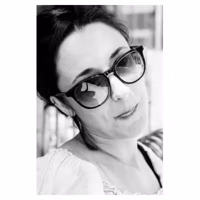 Portrait noir et blanc en extérieur d'une jeune femme tirant la langue