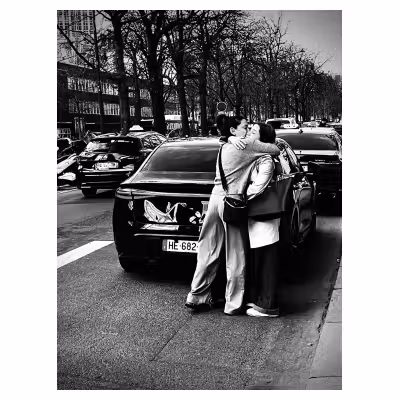 photographie en noir et blanc de deux femmes s'enlaçant tendrement dans la rue