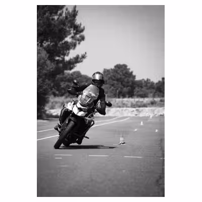 photographie noir et blanc d'une moto en slalom