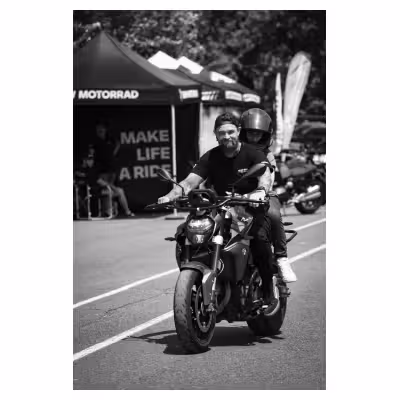 un moniteur de conduite moto souriant avec une passagère