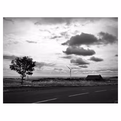 paysage en noir et blanc avec un arbre, une éolienne, un cabane