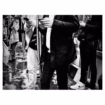 photo en noir et blanc de personnes rivées à leur téléphones dans un tramway