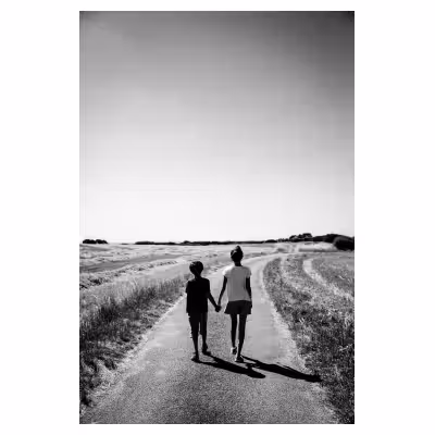 deux enfants de dos se tenant par la main sur une route de campagne