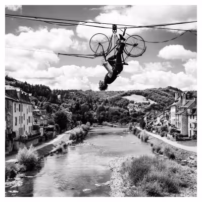 un homme en équilibre sur un vélo renversé sur une corde tendue