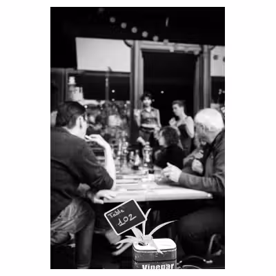 photographie d'un groupe de personnes d'âges mûrs déjeunant à la terrasse d'un café
