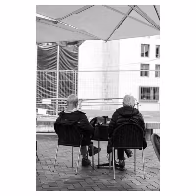 Deux personnes âgées de dos à une terrasse de café