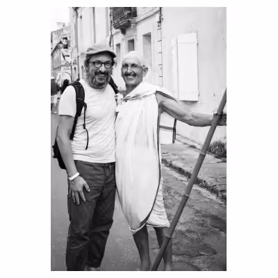 photographie en noir et blanc de deux hommes, dont un déguisé en Gandi