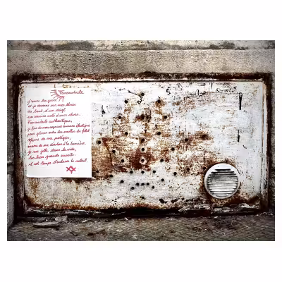 Poème collé sur une plaque métallique rouillée au pied d'un mur