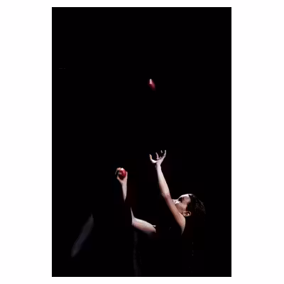 photographie d'un enfant dans le noir lançant une balle rouge