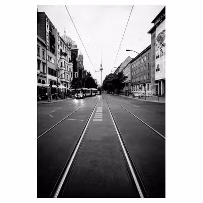 vue fuyante de rails de tramway dans une rue de Berlin avec la tour Fernsehturm de Berlin en arrière plan