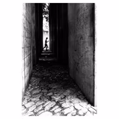 personne à contre jour marchant entre des blocs de béton au musée Juif de Berlin