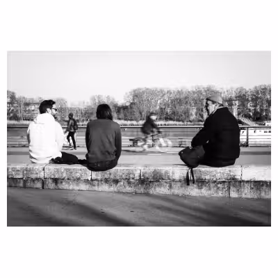photographie noir et blanc de personnes assises sur les quais à Bordeaux