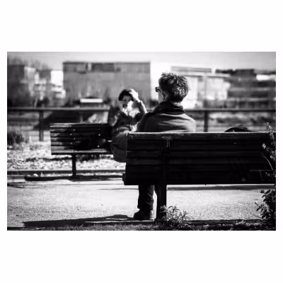 photographie de dos d'une personne assise sur un banc donnant l'impression de n'avoir qu'une jambe