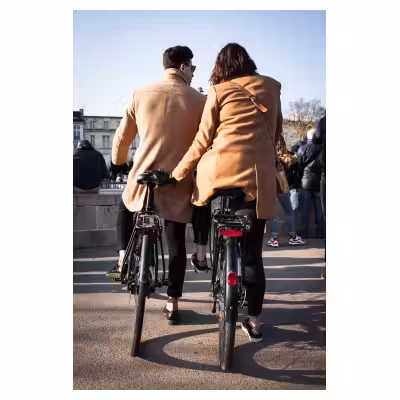 une femme et un homme de dos à vélo habillés de la même manière