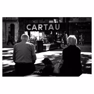 un couple de personnes âgées et leur chien assis sur un banc