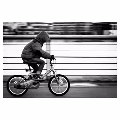 photographie avec un effet filé d'un jeune enfant à vélo