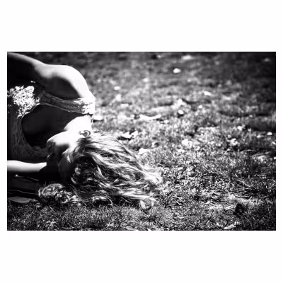 jeune femme allongée dans l'herbe dont les cheveux se mélangent avec l'herbe