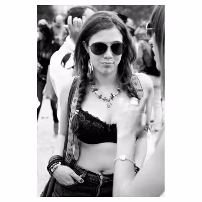 portrait d'une jeune femme en soutien gorge portant des lunettes noires lors d'une gaypride