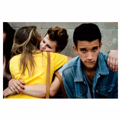 portrait de rue d'un jeune homme assis à côté de deux jeunes femmes s'embrassant