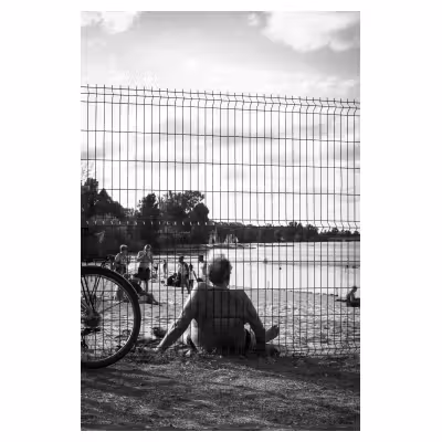 photographie d'un homme en maillot de bain contre un grillage