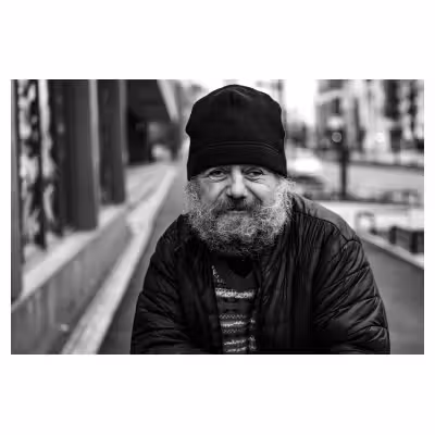portrait en noir et blanc d'un sans domicile fixe souriant avec un bonnet