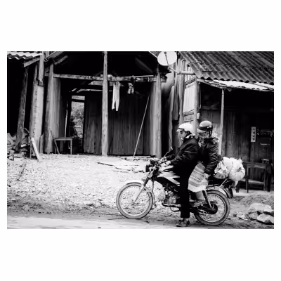 femme vietnamienne en tenue traditionnelle assise derrière un homme sur une moto