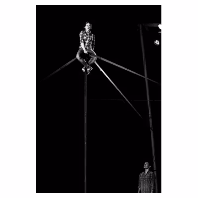 jeune femme artiste de cirque assise en haut d'un mat