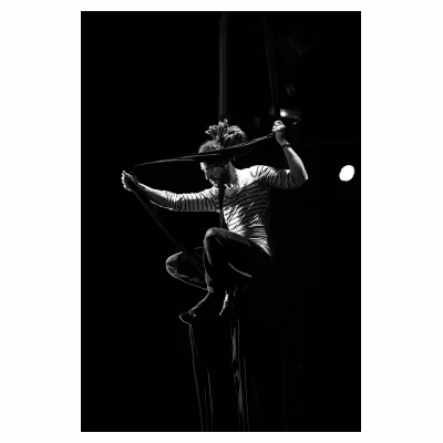 jeune homme artiste de cirque effectuant une figure sur un ruban de tissu