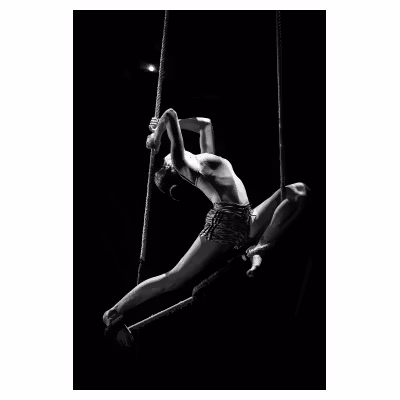 jeune femme artiste de cirque effectuant une figure suspendue à un trapèze