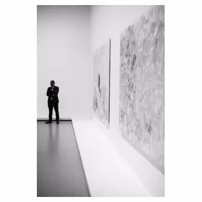 photographie en noir et blanc d'un gardien de musée à proximité de grandes toiles exposées