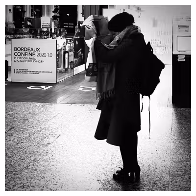 Une femme lit un journal dans le hall de la gare de Bordeaux
