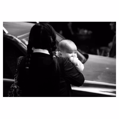 portrait d'une femme vietnamienne portant son enfant dans une rue de Hanoï