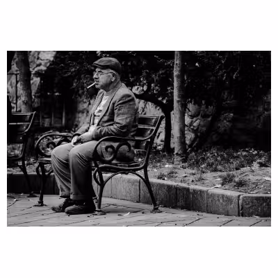 homme qui fumme assis sur un banc à Istanbul