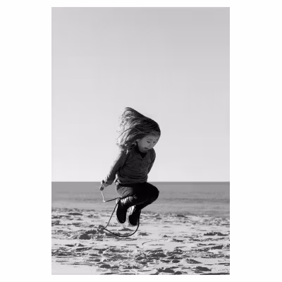une fillette saute à la corde sur une plage