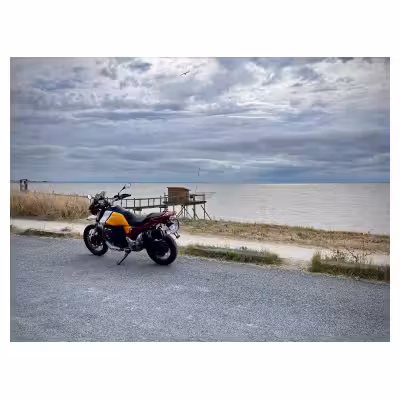 photographie d'un bord de mer avec une Moto Guzzi au premier plan