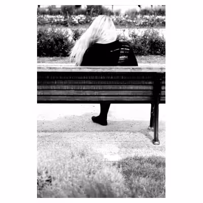 femme de dos assise sur un banc public