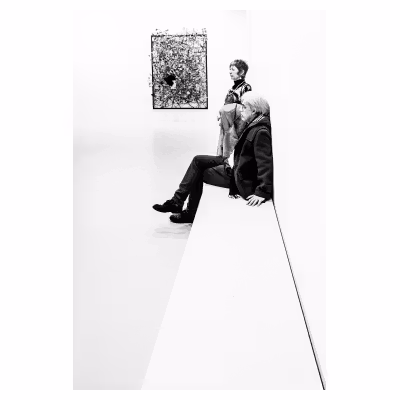 Photo d'une personne assise sur un banc dans une exposition d'art